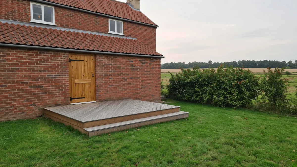 Example image: oak deck silvering behind a red-brick pantiled farmhouse